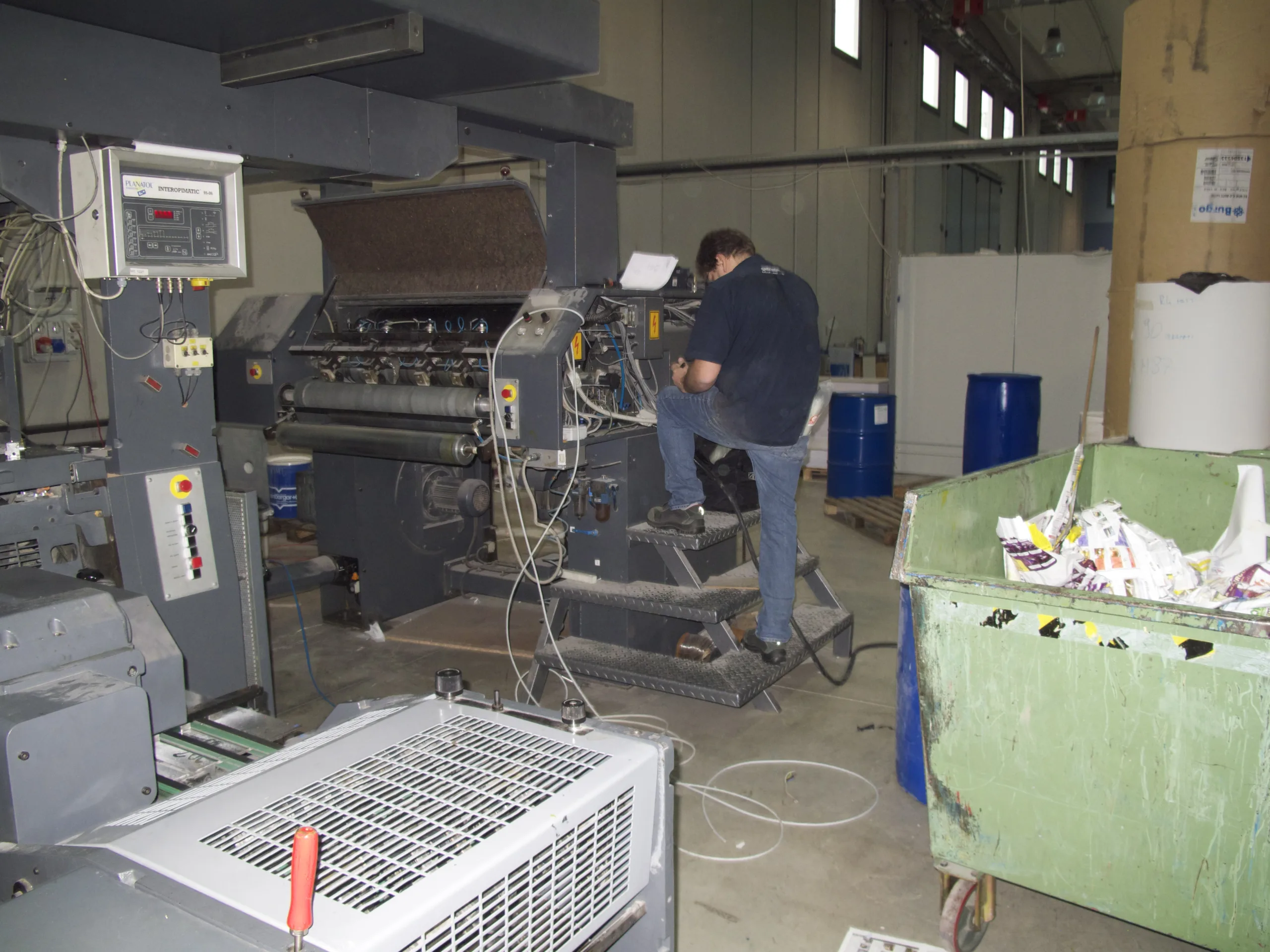 Tecnico al lavoro su un macchinario industriale in officina
